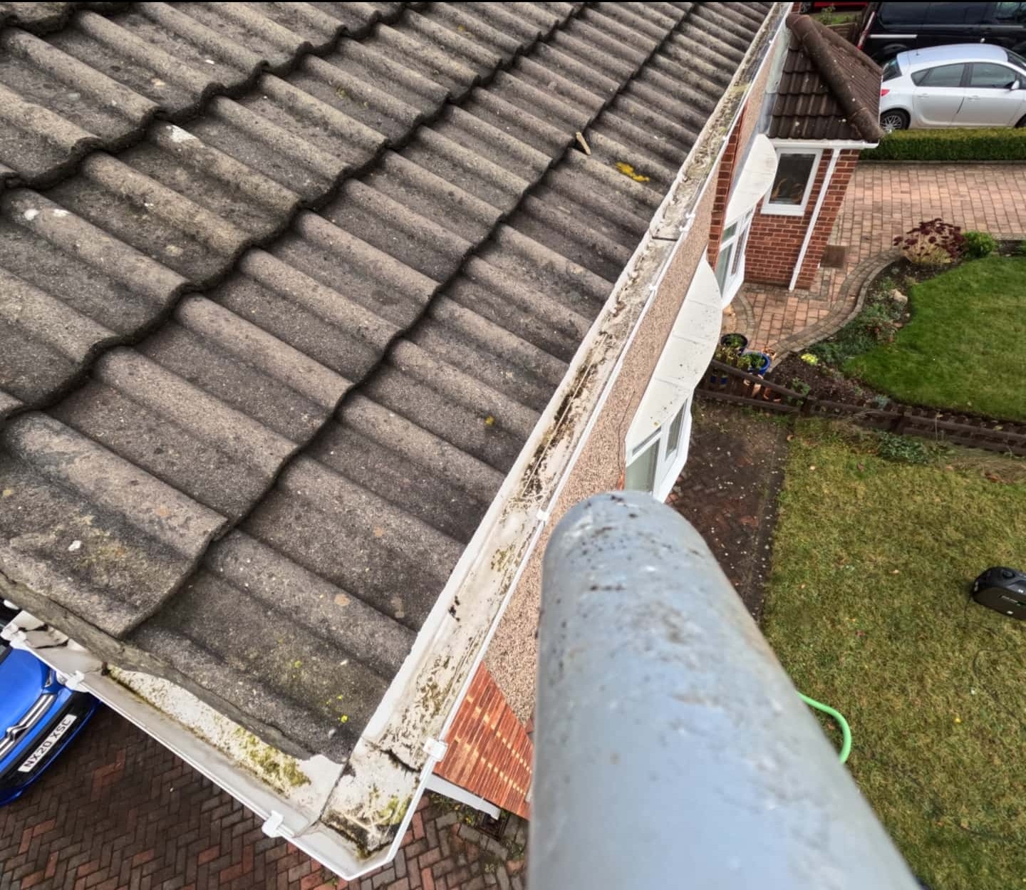 Operation Clean team member clearing blocked gutters on a Stockton home using skyVac